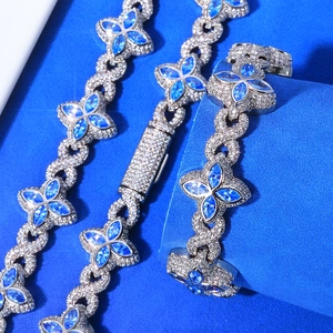 Macro shot of silver hip-hop necklace and bracelet set with blue clover marquise gems