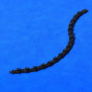 Macro shot of 7.5mm black cubic zirconia hip hop bracelet on blue textured background