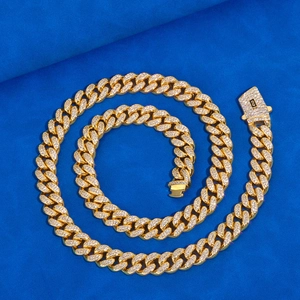 Dettaglio macro catena cubana 12mm oro con zirconi incastonati su velluto blu