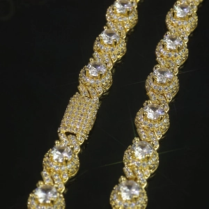 Macro shot of gold hip hop link chain with handset sparkling round cubic zirconia stones