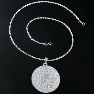 Détail du pendentif hip hop Stay Humble Hustle Hard avec strass blancs sur chaîne corde