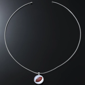 Hip hop style silver necklace with football pendant and pearl chain on a black mirror