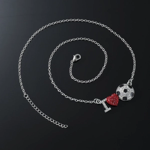 Silver chain necklace with crystal I heart football pendant on reflective black surface