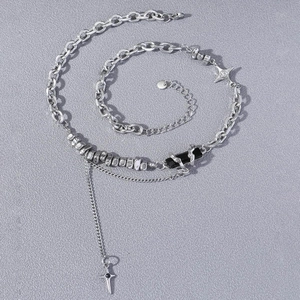 Collier punk argenté avec breloque carrée noire et pendentif croix étoile sur fond gris