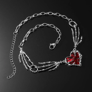 Collier gothique punk avec main de squelette argentée et pendentif cœur rouge
