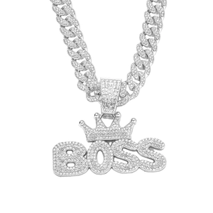 Macro shot of silver-tone iced out crown BOSS pendant on a zircon Cuban link chain