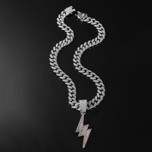 Macro view of pink rhinestone lightning pendant on iced out Cuban link chain necklace
