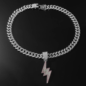 Macro detail of iced out silver Cuban chain with pink and silver lightning bolt pendant
