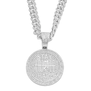Macro detail of iced-out Stay Humble Hustle Hard pendant with silver Cuban link chain