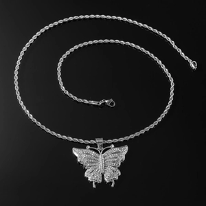 Vue détaillée du pendentif libellule argenté avec cristaux sur fond noir réfléchissant