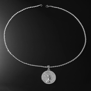 Vue macro d'une chaîne corde argentée et d'un pendentif Nefertiti serti de cristaux brillants