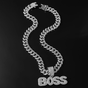 Détail du collier chaîne cubaine argentée avec pendentif BOSS serti de strass