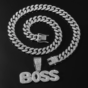 Détail du collier hip-hop argenté avec pendentif BOSS et chaîne cubaine sertie de strass