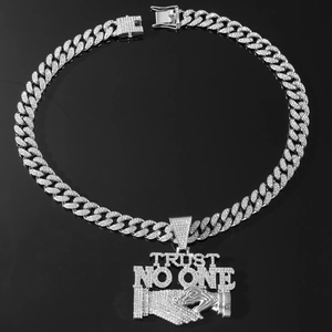 Macro shot of silver Cuban chain with diamond-encrusted Trust No One pendant detail
