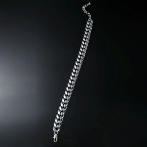 Detail of silver Cuban link anklet featuring a lobster clasp and adjustable extension chain