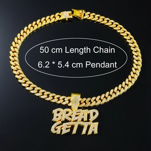 Gros plan d'une chaîne cubaine dorée avec pendentif BREAD GETTA serti de strass