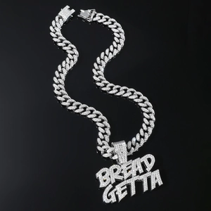 Gros plan du pendentif hip-hop BREAD GETTA argenté avec cristaux étincelants pavés