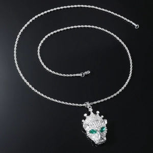 Detail of silver crown leopard pendant with green crystal eyes and rope chain necklace