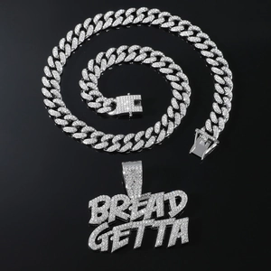 Gros plan du pendentif Bread Getta avec pierres brillantes sur chaîne cubaine argent