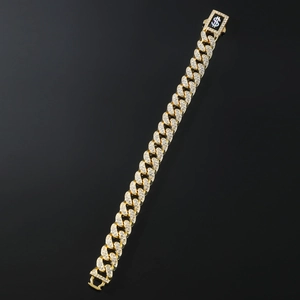 Macro shot of gold Cuban link bracelet with iced-out diamonds and dollar sign clasp