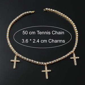 Dettaglio della collana tennis dorata con tre ciondoli a croce scintillanti