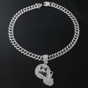 Makroaufnahme einer silbernen kubanischen Kette mit funkelndem Emoji-Anhänger mit Diamanten
