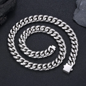 Collier gourmette en acier inoxydable poli avec boucle carrée sur fond de roche noire