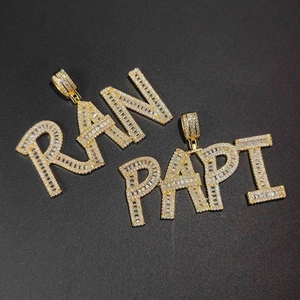 Macro view of iced out custom hip hop letter pendants with baguette and round cut stones
