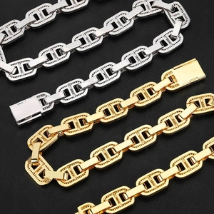 Dettaglio di maglie cubane in oro e argento con pavé di zirconi cubici incastonati