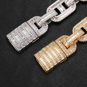 Dettaglio macro di bracciali a maglie cubane in oro e argento con pietre di zirconi