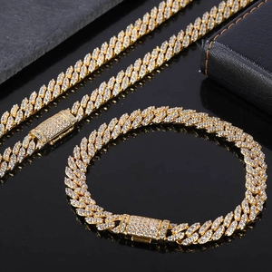 Detailed macro view of iced out golden Cuban link chains with clear zircon inlays