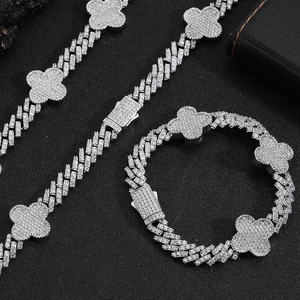 Dettaglio del set collana e bracciale a maglia cubana in argento con quadrifogli e zirconi