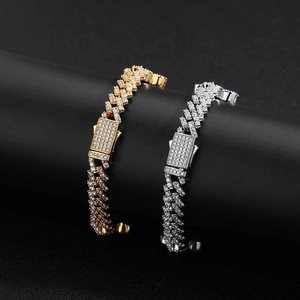 Bracciali a catena cubana con zirconi in finitura oro e argento su supporto nero di lusso