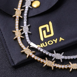 Detailed macro view of gold and silver barbed wire tennis chains with white cubic zirconia