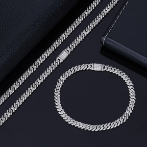 Détail macro d'un ensemble de chaîne et bracelet cubain argenté serti de faux diamants