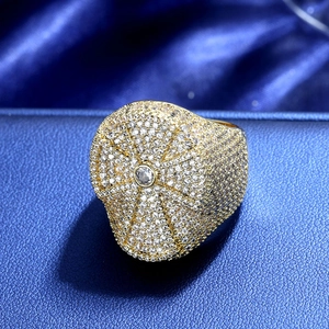 Anello hip-hop uomo dorato con croce di zirconi e pavé di cristalli su sfondo in pelle blu