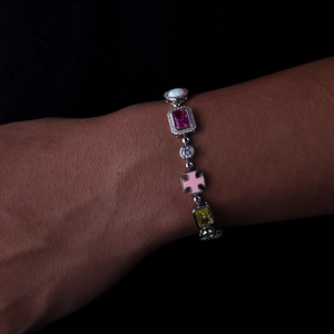 Dettaglio del bracciale con pietre preziose colorate, rubino, opale e ciondolo a croce