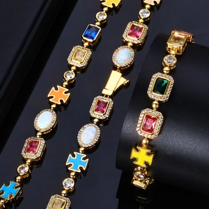 Trois bracelets hip hop plaqués or avec pierres précieuses colorées et croix sur support