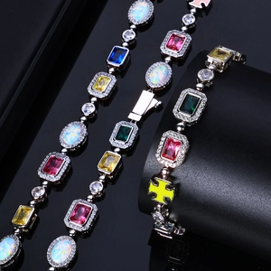 Détail macro de bracelets avec pierres précieuses colorées, opales et pendentifs croix