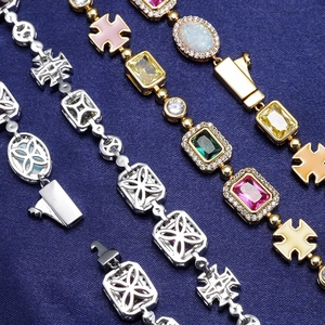 Dettaglio di bracciali con gemme colorate, micro-diamanti e ritagli del logo