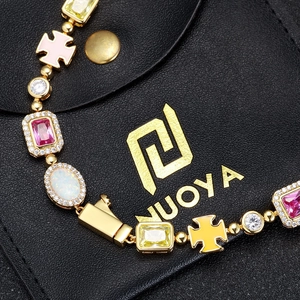Dettaglio del bracciale a sfere dorate con croci in smalto colorato e ciondoli con gemme