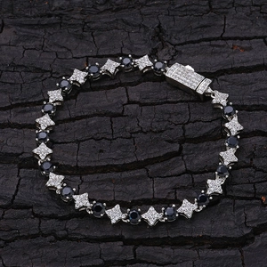 Dettaglio di un bracciale tennis argento con pietre nere tonde ed elementi a forma di stella