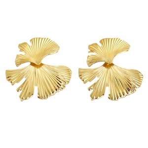 Vintage gold ginkgo leaf dangle earrings with textured metallic finish on white background