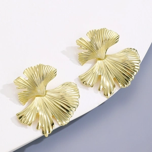 Detailed macro view of golden ginkgo leaf earrings with radial pleated textures