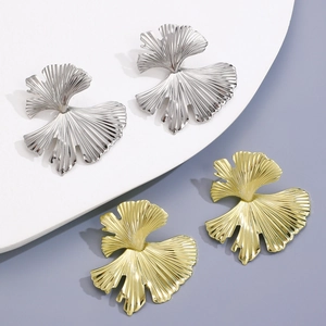Macro detail of textured ginkgo leaf dangle earrings in gold and silver finish