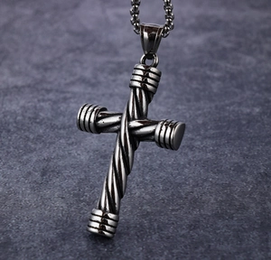 Close-up of men's stainless steel cross pendant with detailed woven texture design.