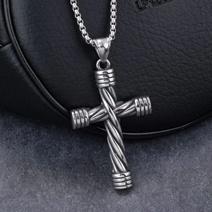 Detailed macro view of a men's stainless steel cross pendant featuring twisted metal texture