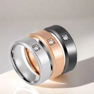 Detailed macro view of three titanium steel rings with square stones in silver, gold, and black