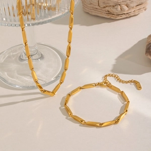 Elegant gold titanium steel jewelry set featuring a geometric faceted necklace and bracelet