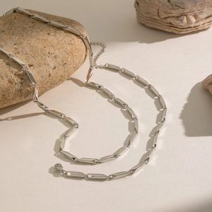 Detail showing minimalist silver rhombus chain link necklace with lobster clasp and extender